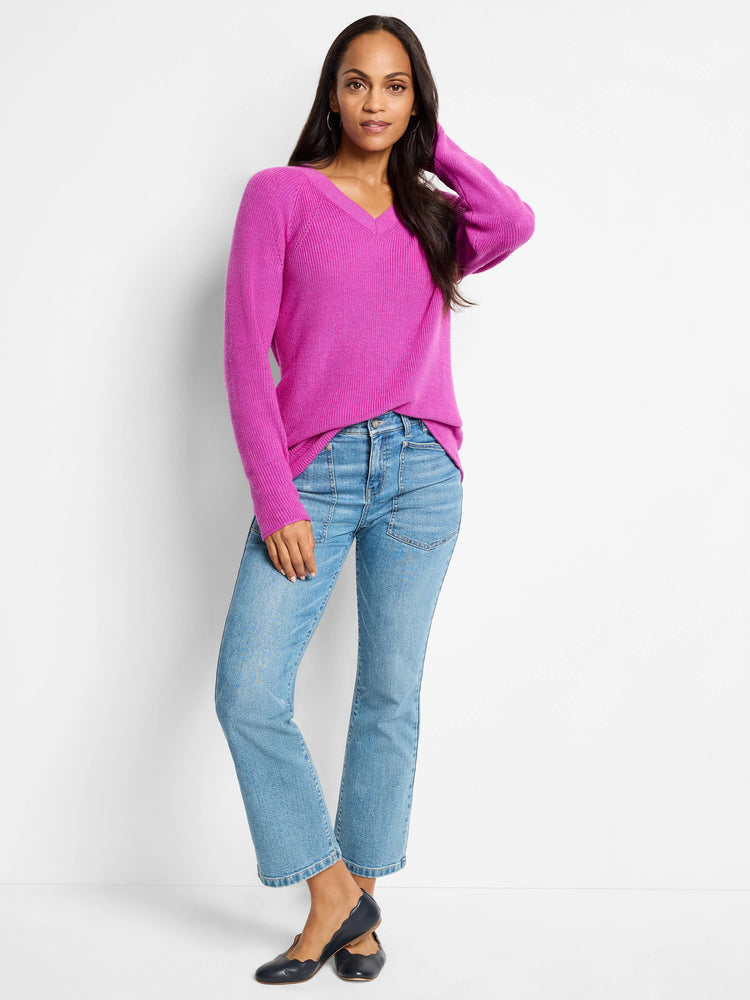 Fuchsia V-neck cashmere blend sweater. Long sleeves.  Model shown wearing light wash jeans & dark flats.
