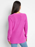 Fuchsia V-neck sweater, long sleeves,  ribbed knit texture with  eyelet detailing at shoulders.