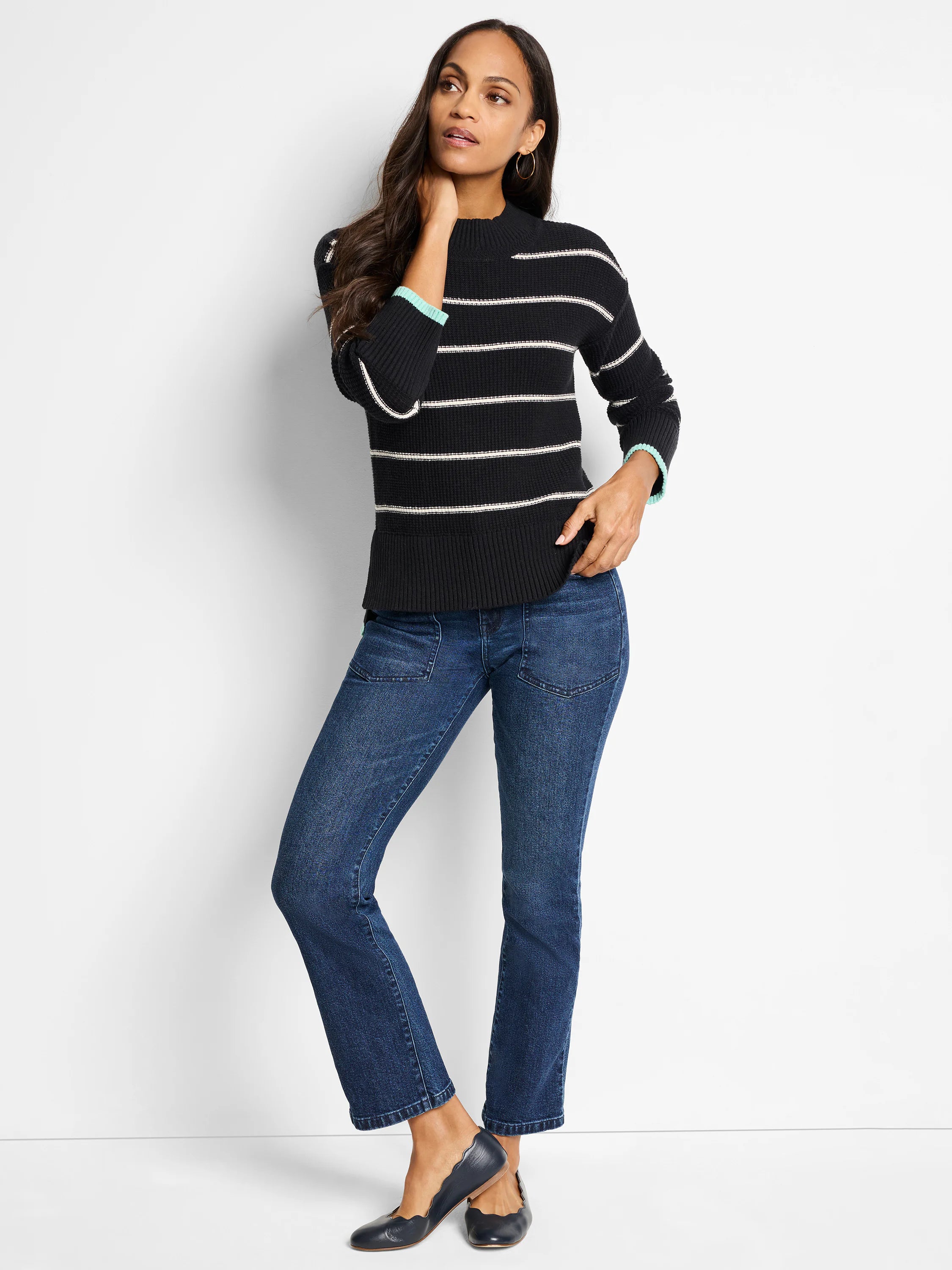 Black waffle-knit sweater with thin, horizontal off-white stripes and teal cuffs.