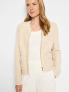 Cream-colored sherpa jacket with gold zipper,  small pockets, and fitted silhouette.