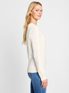 Off-white, long-sleeved v-neck sweater.  Side view shows fit and ribbed cuffs.