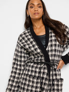 Reversible jacket; black & cream houndstooth pattern on one side, black on the other.  Features pockets and a self-tie belt.
