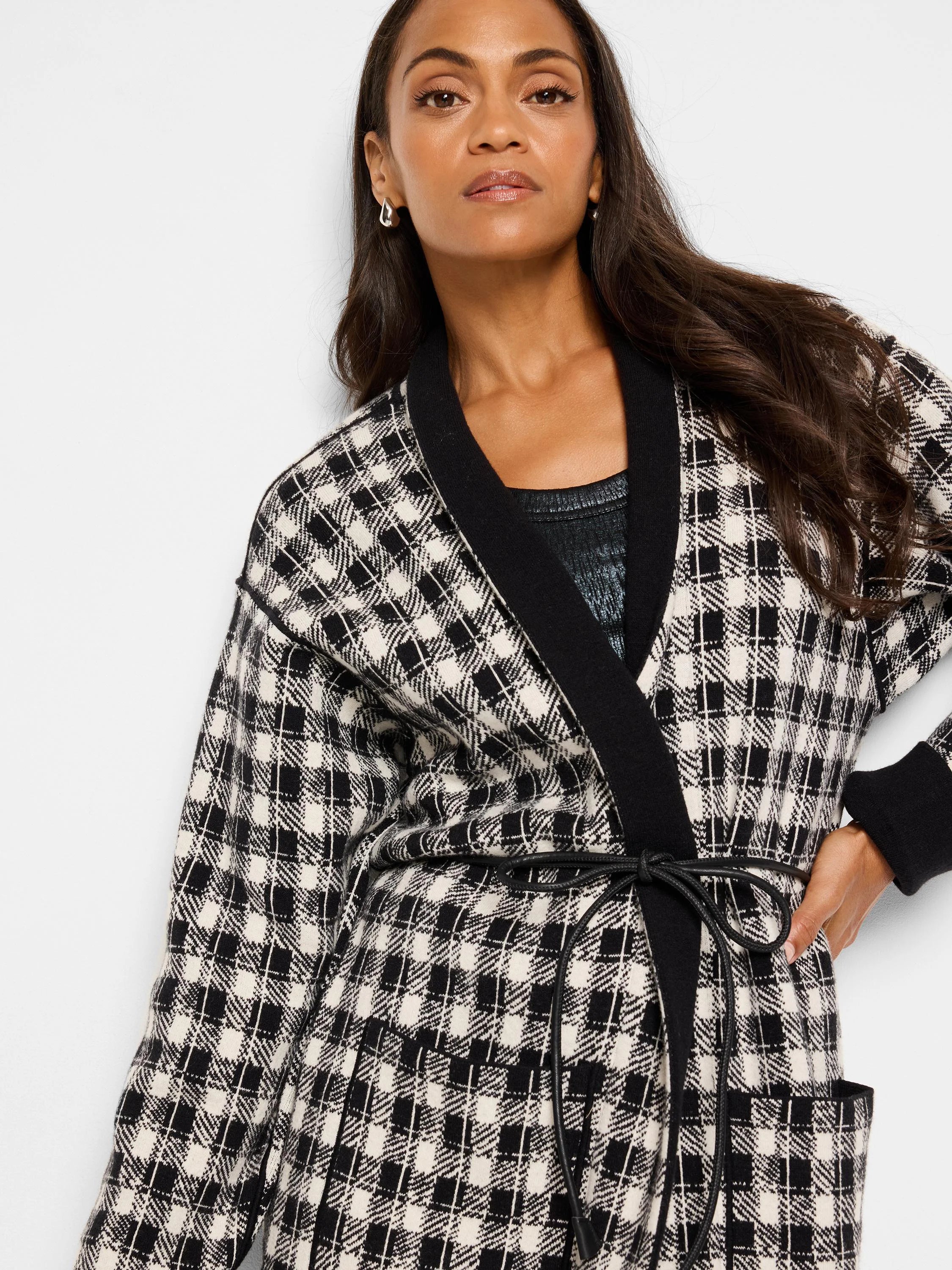 Reversible jacket; black & cream houndstooth pattern on one side, black on the other.  Features pockets and a self-tie belt.