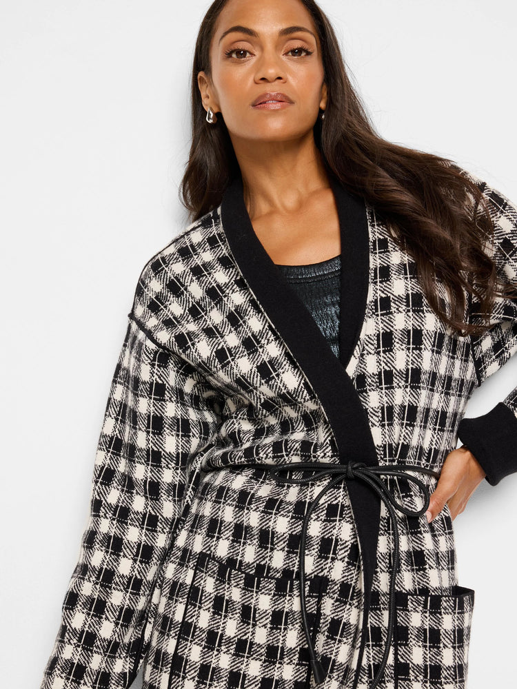 Reversible jacket; black & cream houndstooth pattern on one side, black on the other.  Features pockets and a self-tie belt.