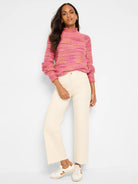 Pink, orange, and yellow horizontal striped knit turtleneck sweater with long sleeves.