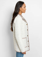 Off-white quilted puffer jacket with taupe trim & shiny metallic taupe reversible side. Features gold snap buttons.