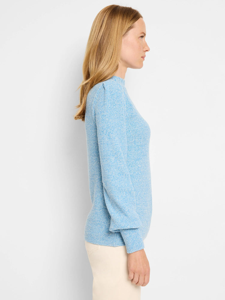 Marled light blue waffle stitch sweater with puffed sleeves, worn by a woman.