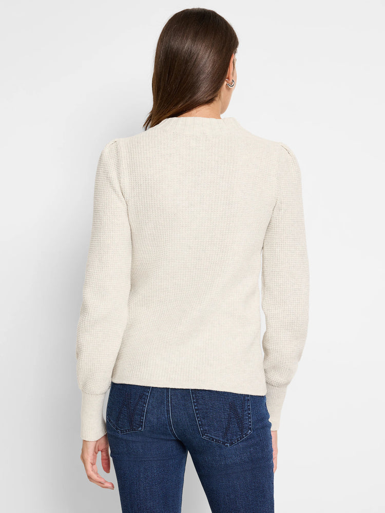 Cream waffle stitch sweater, mock neck, long sleeves with slight puff shoulders. Shown from the back.