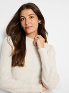 Cream waffle stitch sweater with a mock neck and ribbed cuffs.