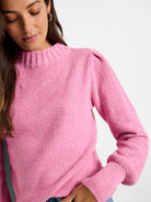 Pink waffle stitch sweater with ribbed mock neck, puffed shoulders, and ribbed cuffs.
