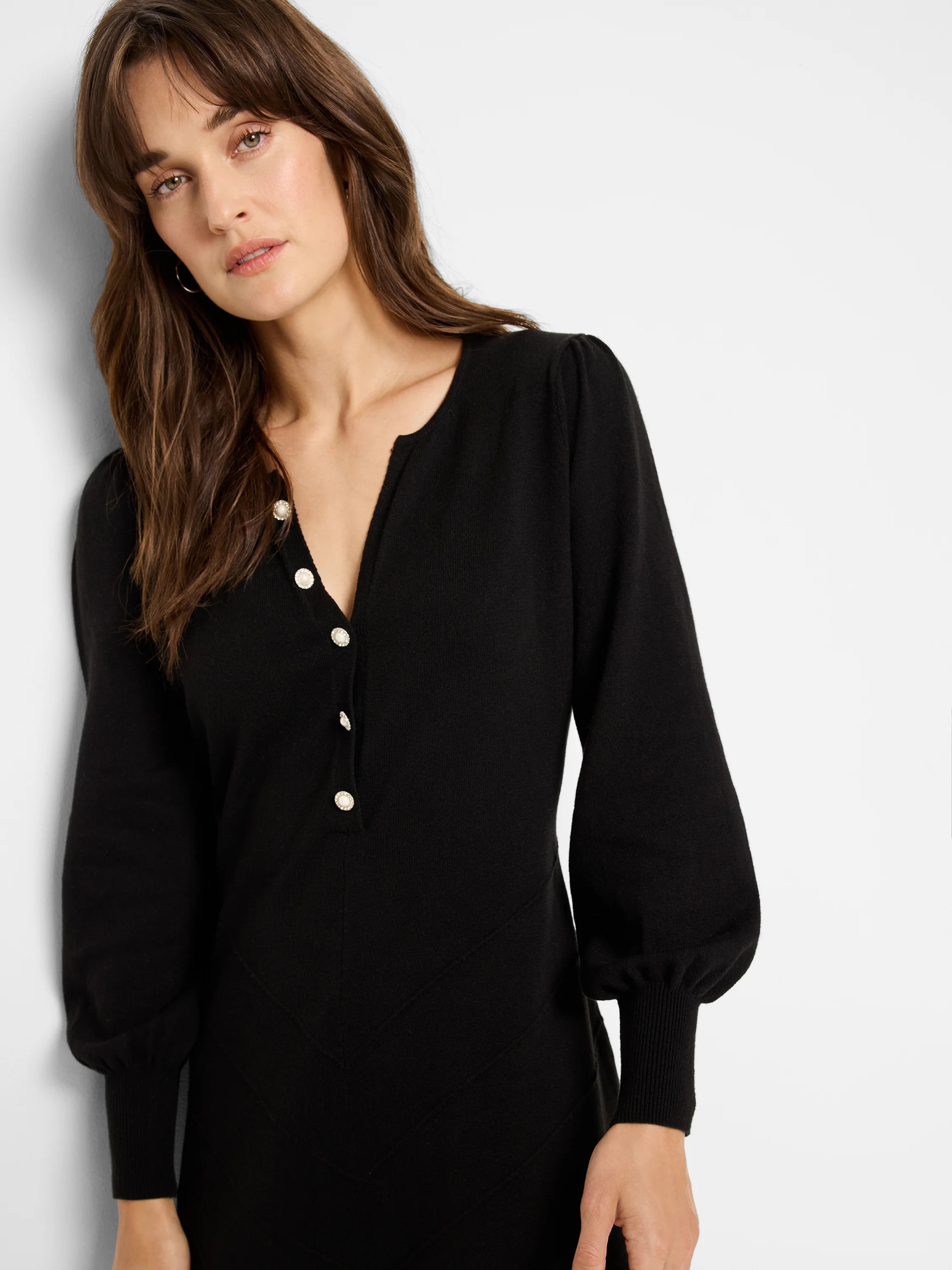 Black long-sleeved midi dress with subtle diagonal seaming and pearl-like buttons.  Long sleeves have cuffed ends.