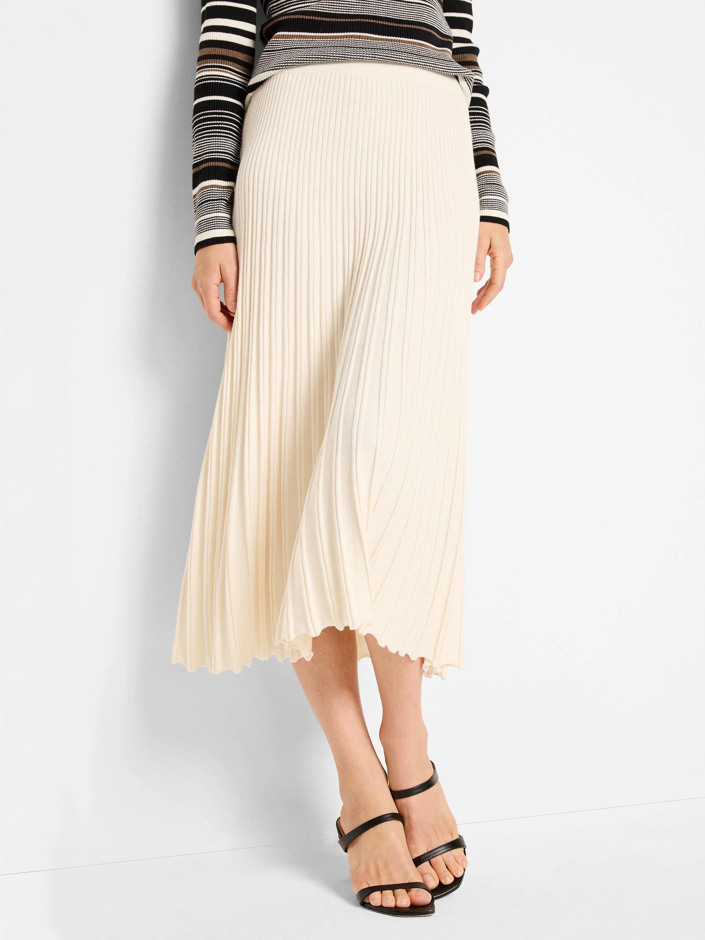 Cream ribbed sweater skirt, midi-length, with a scalloped hem.