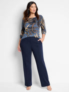 Navy blue wide-leg pleated pants;  model wears them with a blue, brown, and gold patterned top.