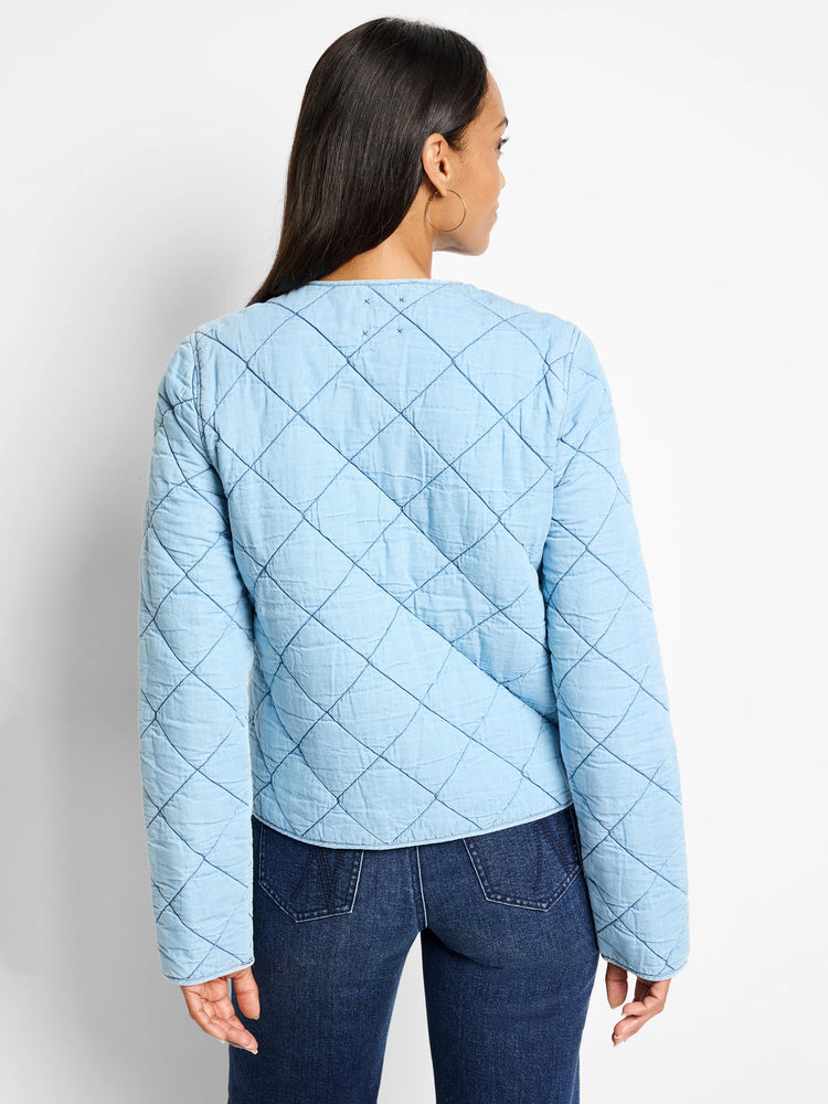 Light blue quilted denim jacket. Diamond quilting pattern. Long sleeves.  Back view.