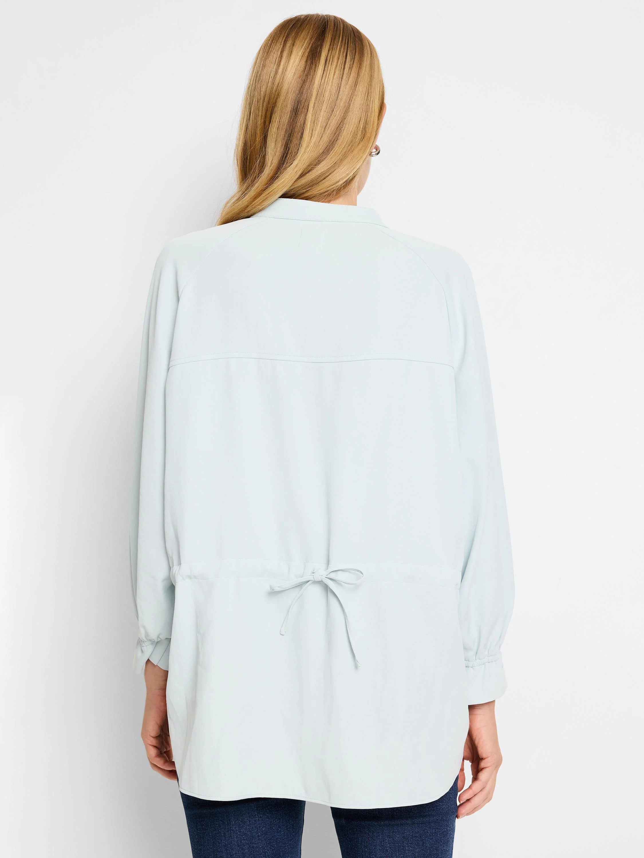 Light blue collared shirt with long sleeves and a drawstring waist.  Back view.