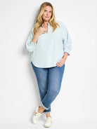 Light blue, 3/4 sleeve blouse with a slight V-neck and gently puffed sleeves.