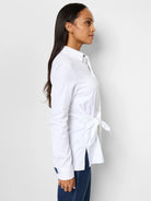 White long-sleeve collared shirt with side tie detail.  The shirt is shown on a model.