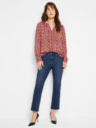 Long-sleeve blouse, v-neck, geometric print in pink, orange, gray, and black on dark background.