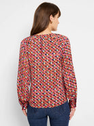Long-sleeved top, pink, brown, and gray geometric pattern on a dark background.  Slight V-neck.