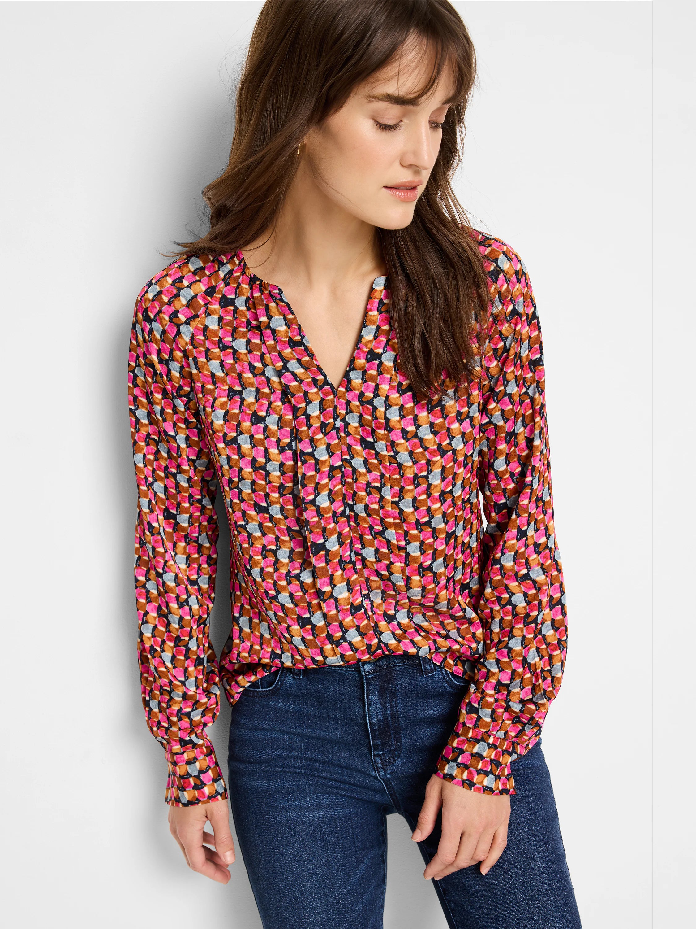 Long-sleeve blouse, V-neck.  Pink, brown, gray, and black geometric pattern on dark background.