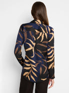 Long-sleeved blouse, dark navy, black, and tan leaf pattern.  Back view.