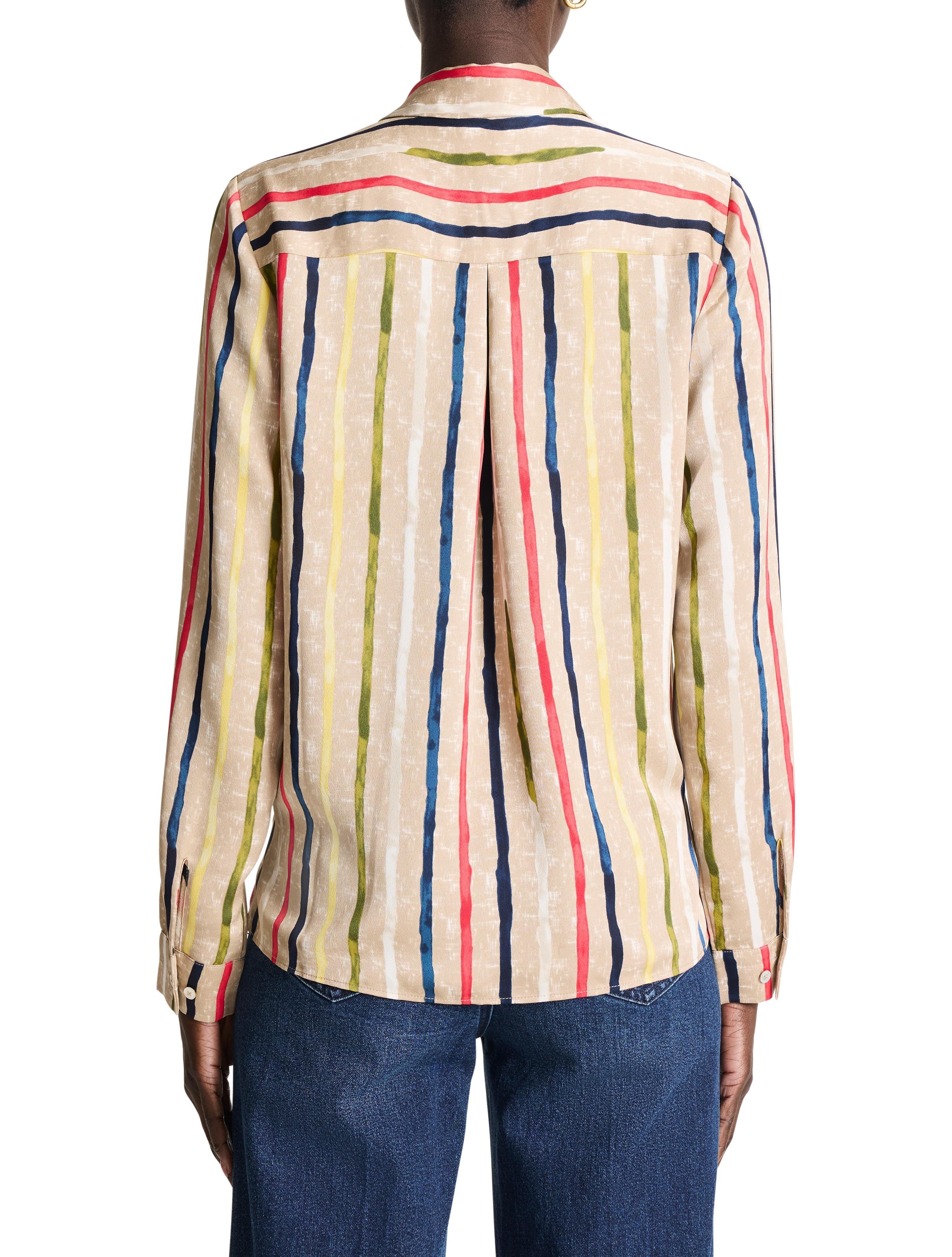 Beige long-sleeve top with painted vertical stripes in red, blue, yellow, green, and white. Model's back.