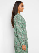 Green, cream, and black abstract dot print long-sleeve blouse.