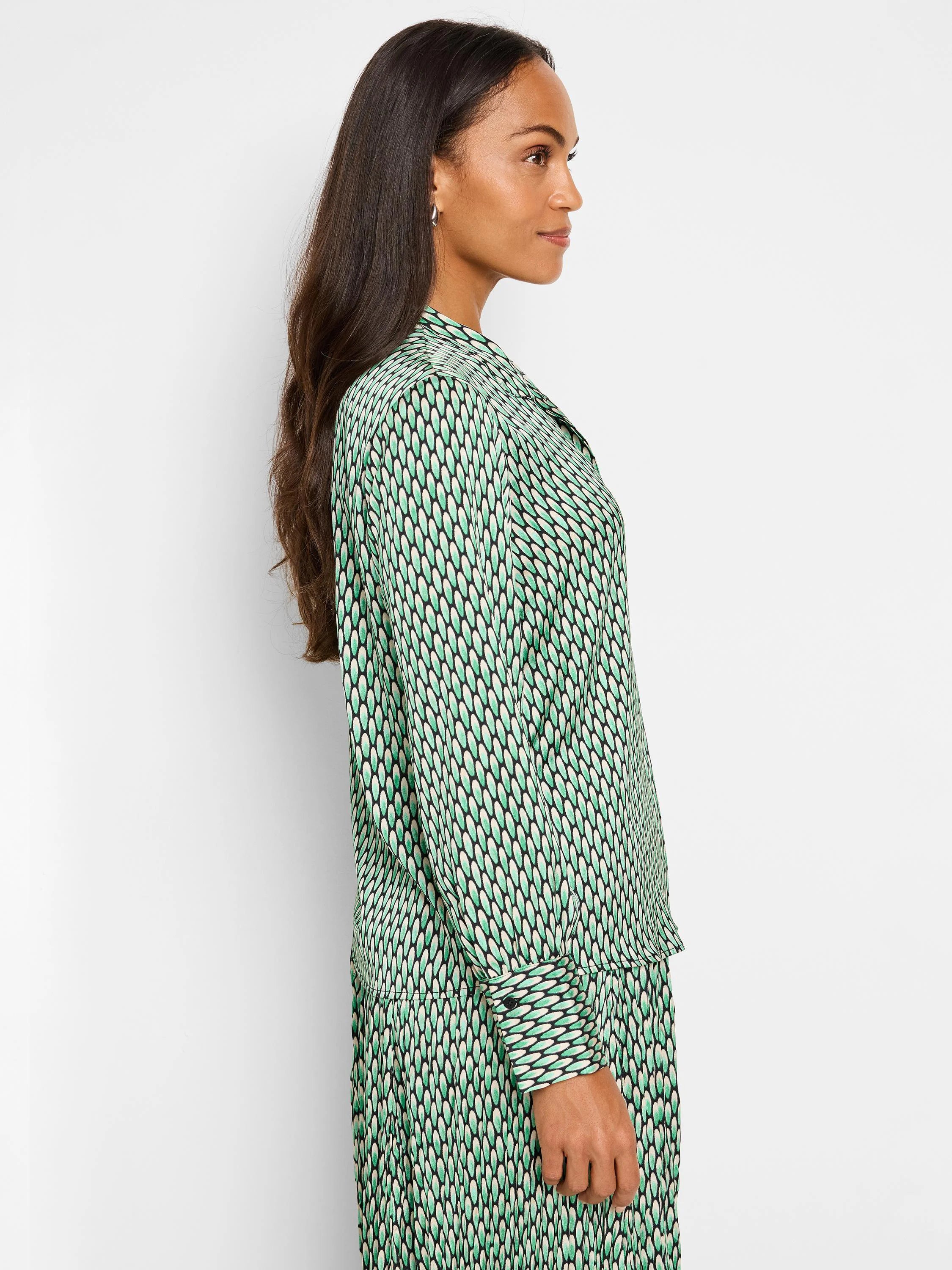 Green, cream, and black abstract dot print long-sleeve blouse.