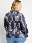 Dark navy shirt with off-white zebra stripes in an abstract pattern. Long sleeves, collared.