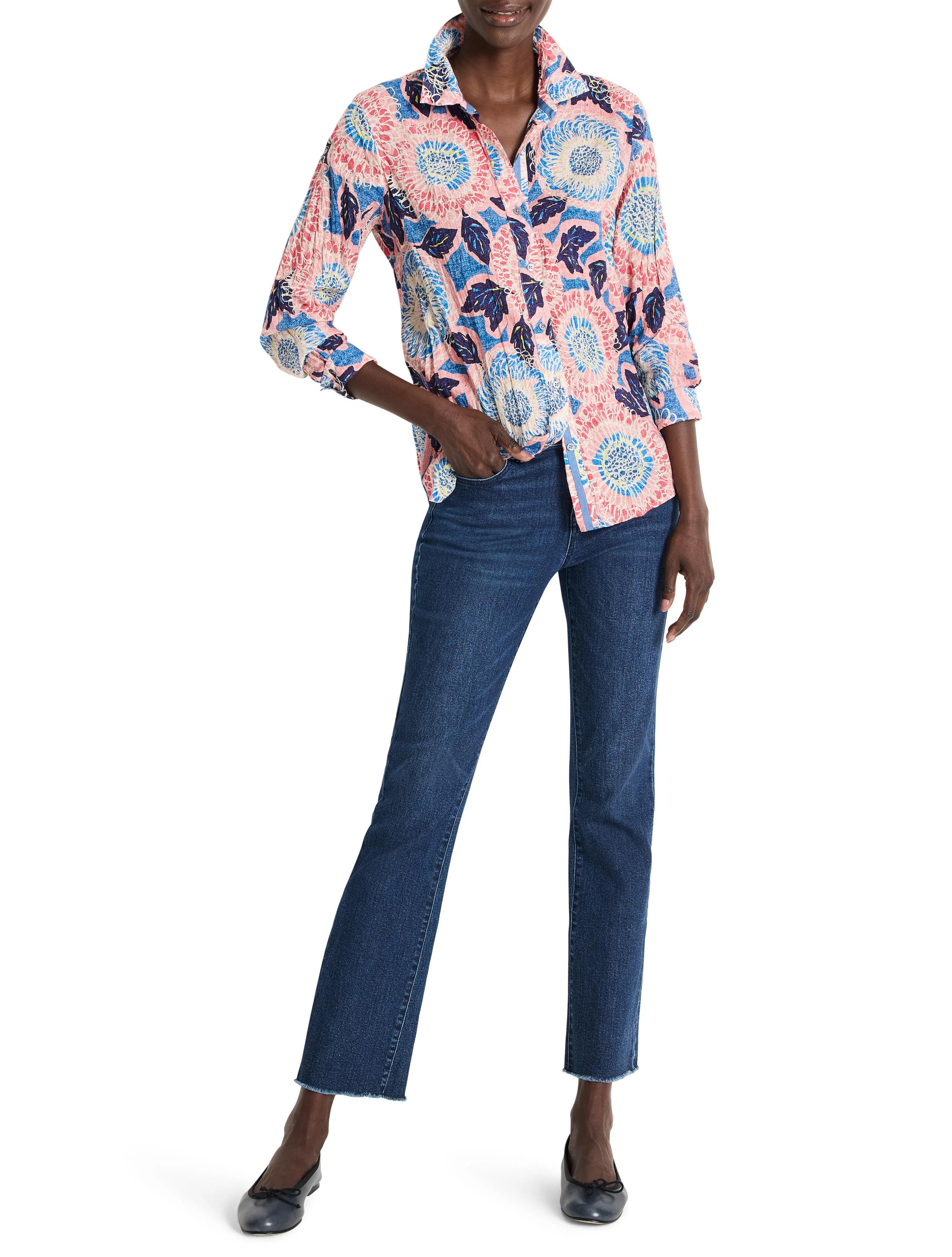 Pink long-sleeved button-down shirt with blue and white floral print.  The model wears dark-wash jeans.