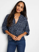 Navy blue top with a light blue and white dot pattern.  Three-quarter sleeves, v-neck.