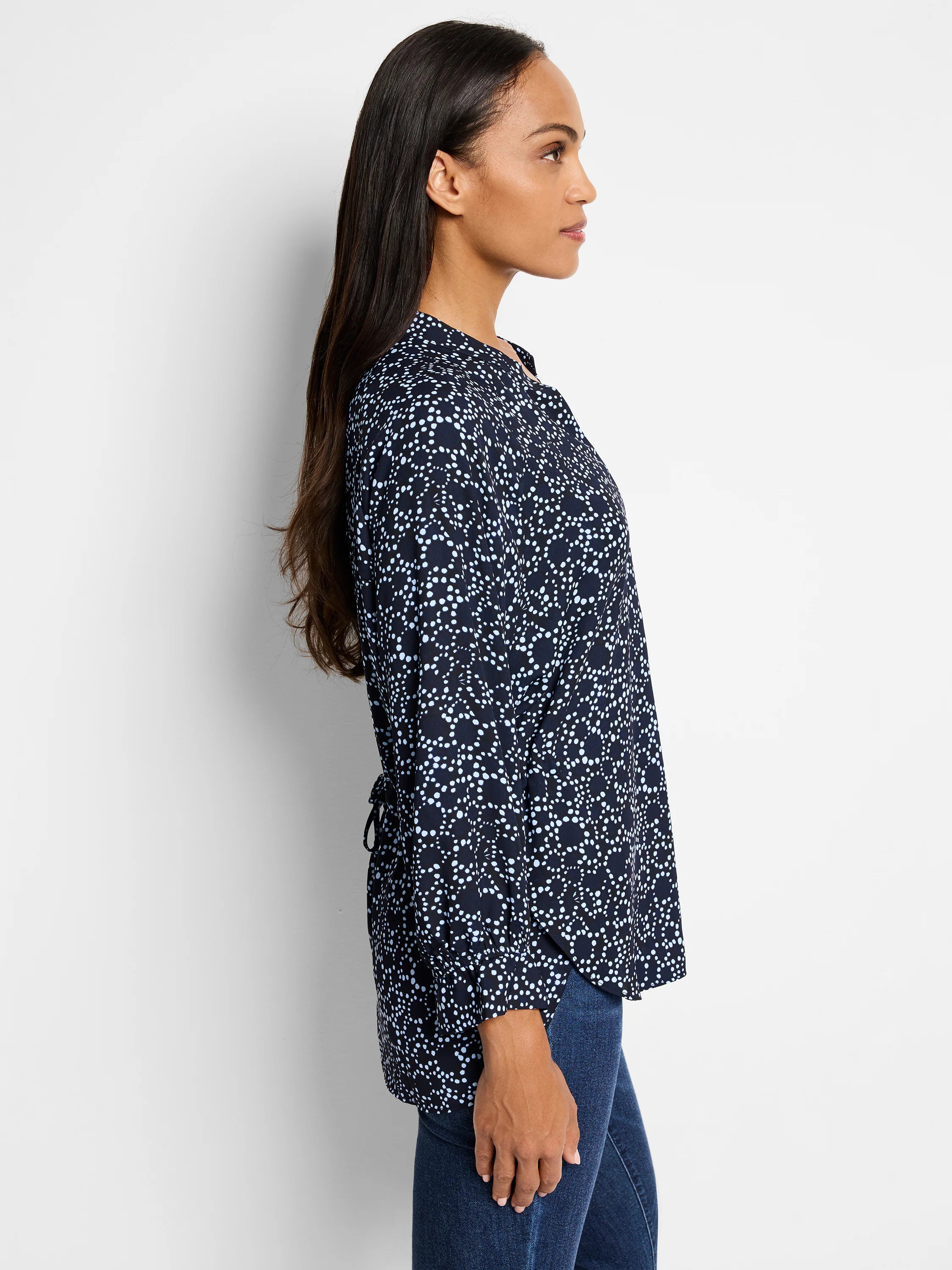 Navy blue top with a light blue dot pattern.  Long sleeves, banded cuffs, and a back tie.