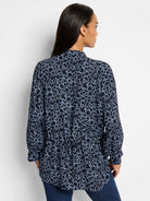 Dark navy top with a light blue polka dot pattern.  Long sleeves, high neck.