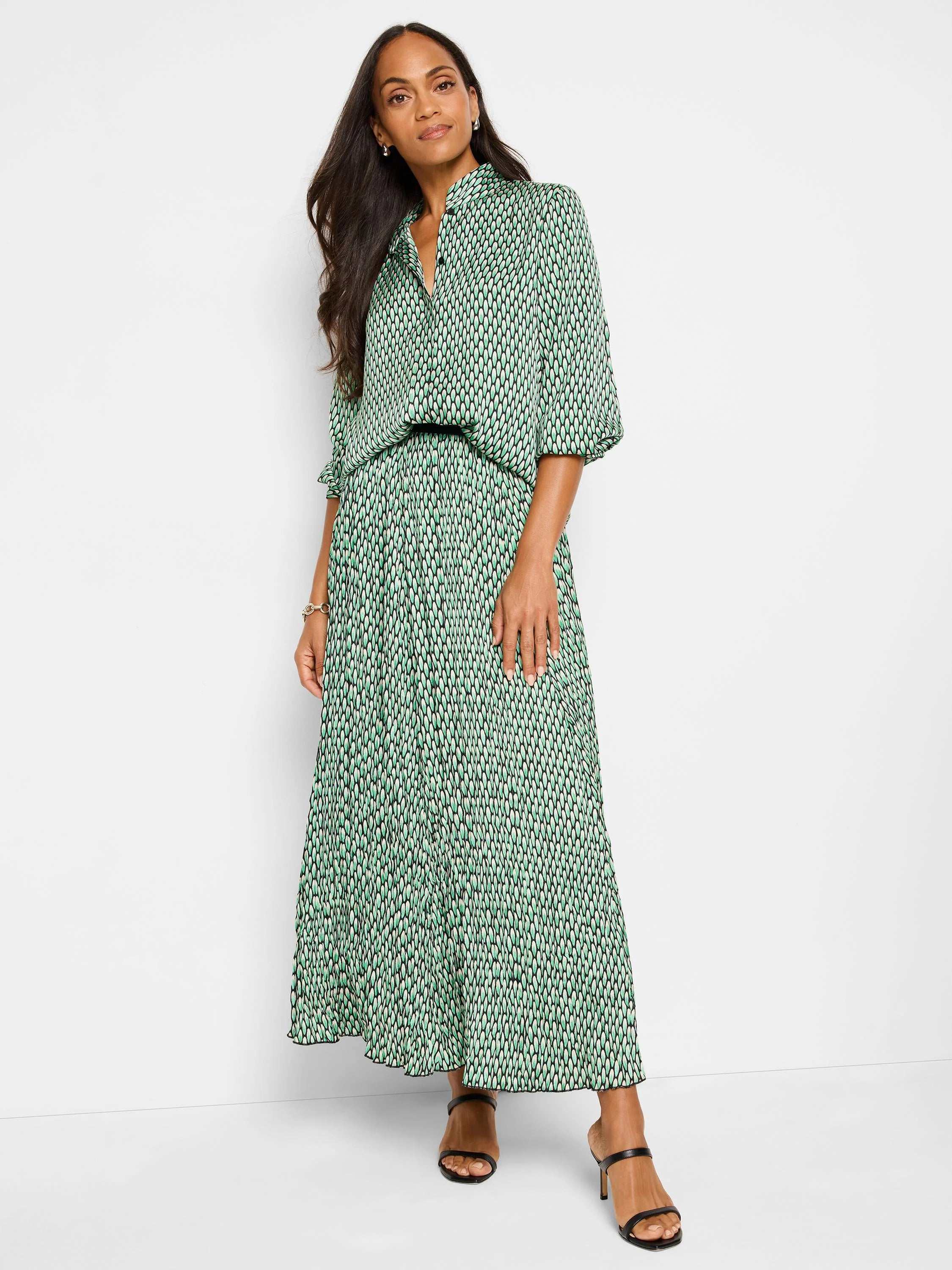 Pleated maxi skirt in green, black, and white abstract dot print.
