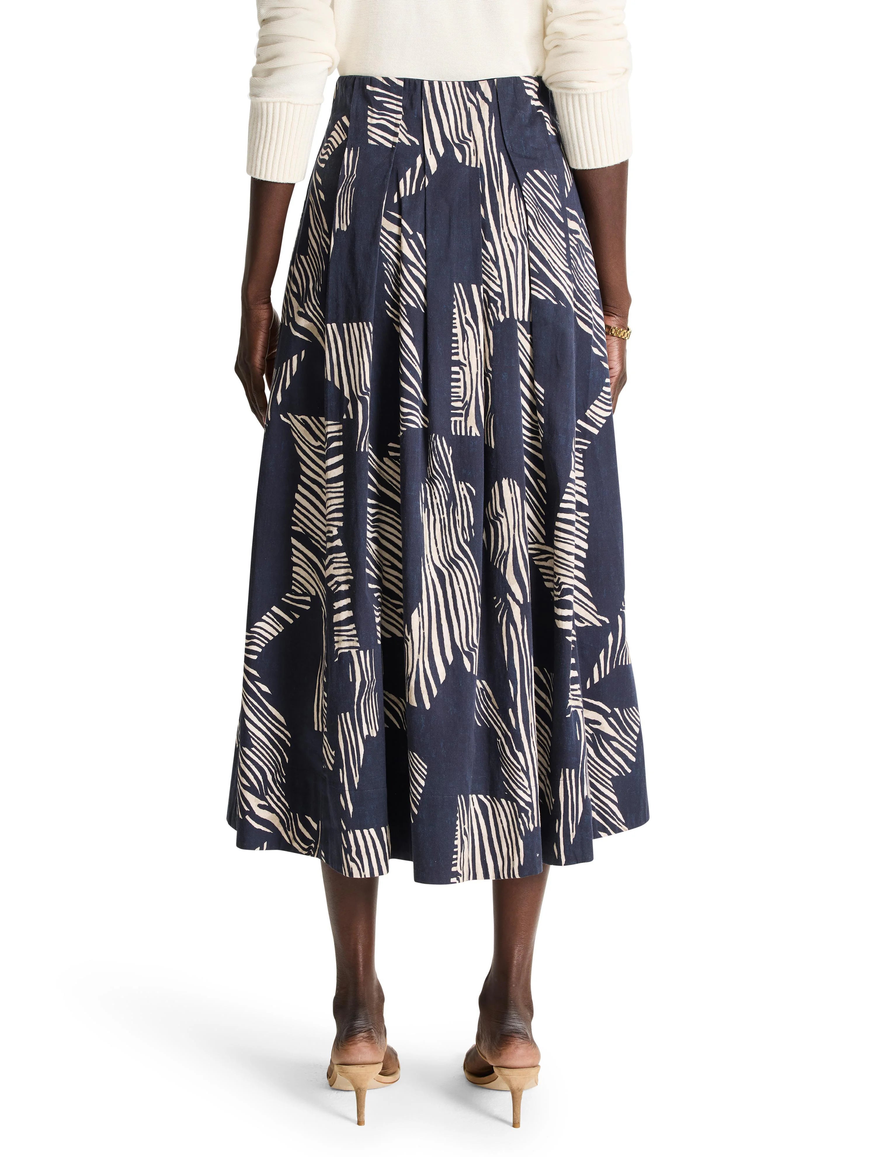 Mid-length pleated skirt; navy blue background with off-white zebra stripes.
