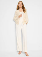 Off-white wide-leg trousers; model wears off-white top and cardigan.  Rose gold heels.