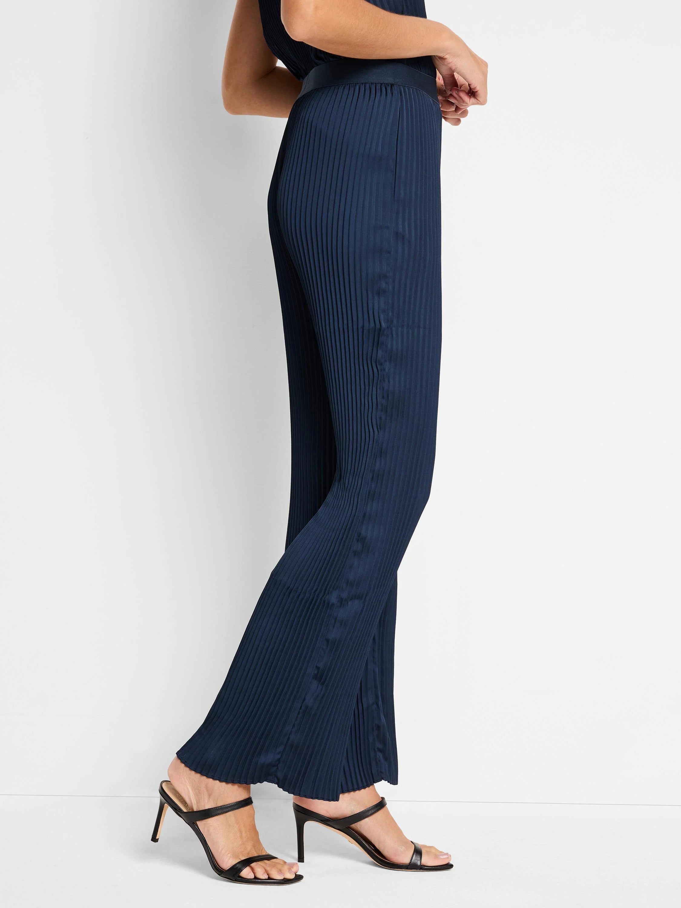 Navy blue, wide-leg pants with vertical pleats.  Shown on a model.