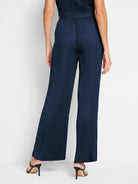 Navy blue, wide-leg pants with vertical pleats.  Back view;  shows a fitted waist.
