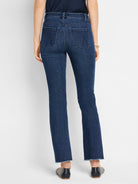 Dark blue, mid-rise demi boot jeans, shown from the back, featuring decorative back pockets and frayed hems.