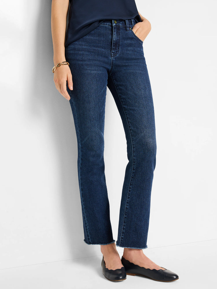 Dark blue denim mid-rise demi boot jeans with a subtle wash and distinct raw, frayed ankle hems.