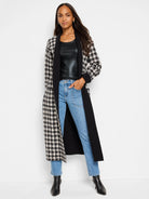 Mid-rise, straight-leg jeans in light blue denim.  Shown with black and cream gingham-patterned coat.