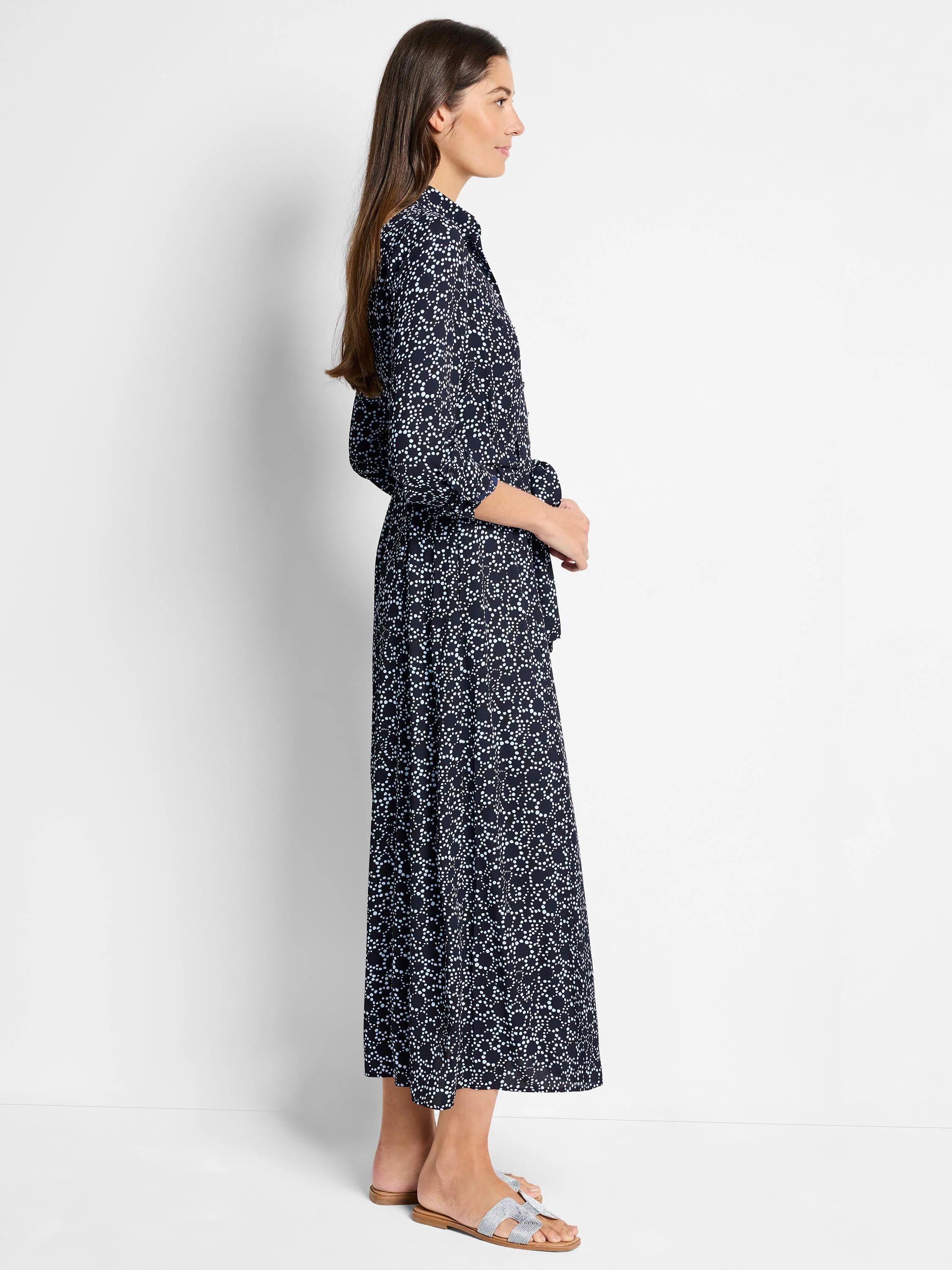Navy maxi dress with light blue dot pattern, belted waist, and three-quarter sleeves.
