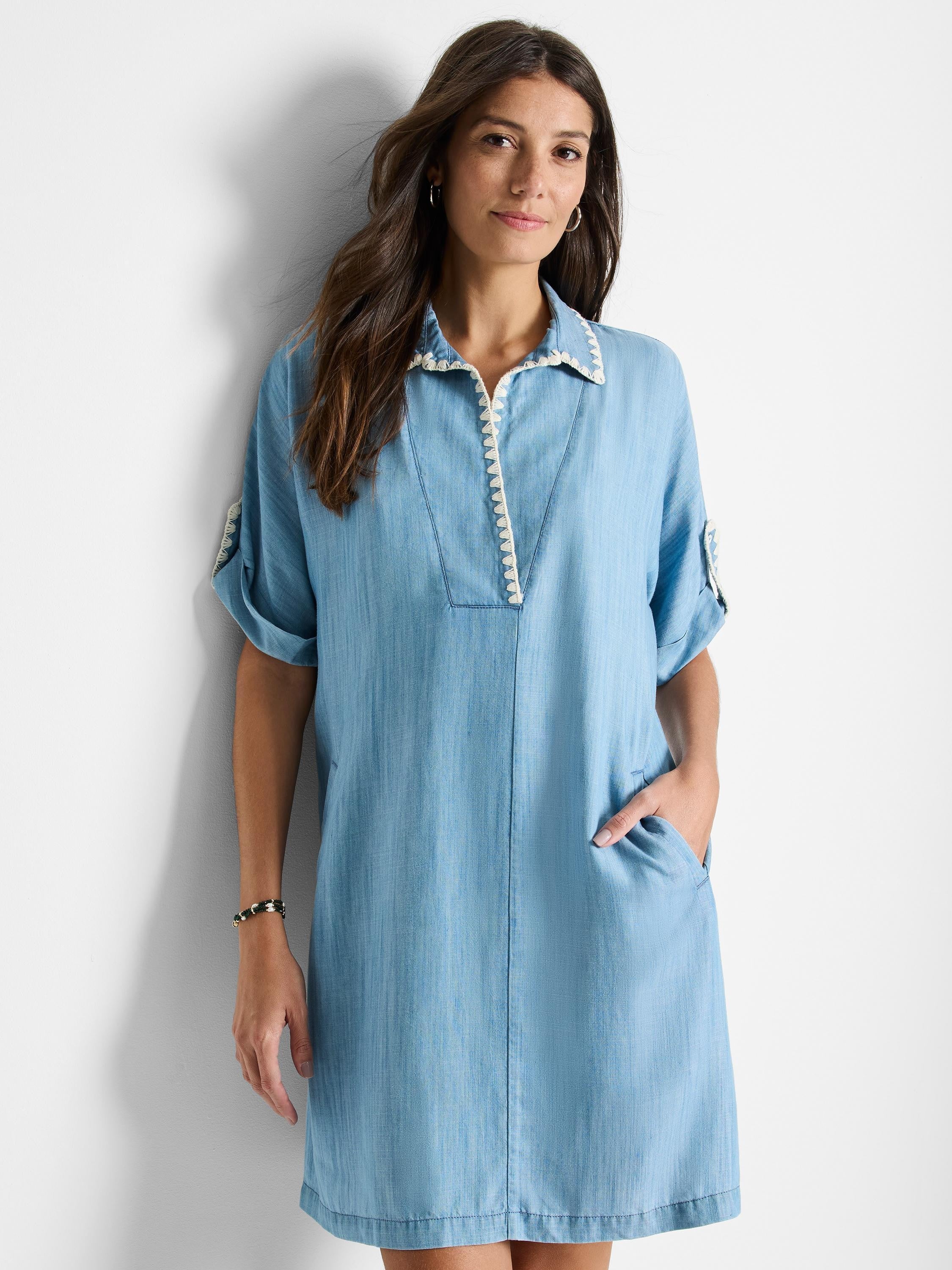 Light blue denim dress, short sleeves, collared neckline with off-white trim, and pockets.