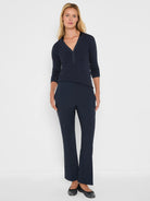 Dark navy ribbed knit V-neck top with long sleeves, featuring a satin-like trim along the neckline and placket.