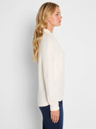 Cream cable knit long-sleeve top on model.