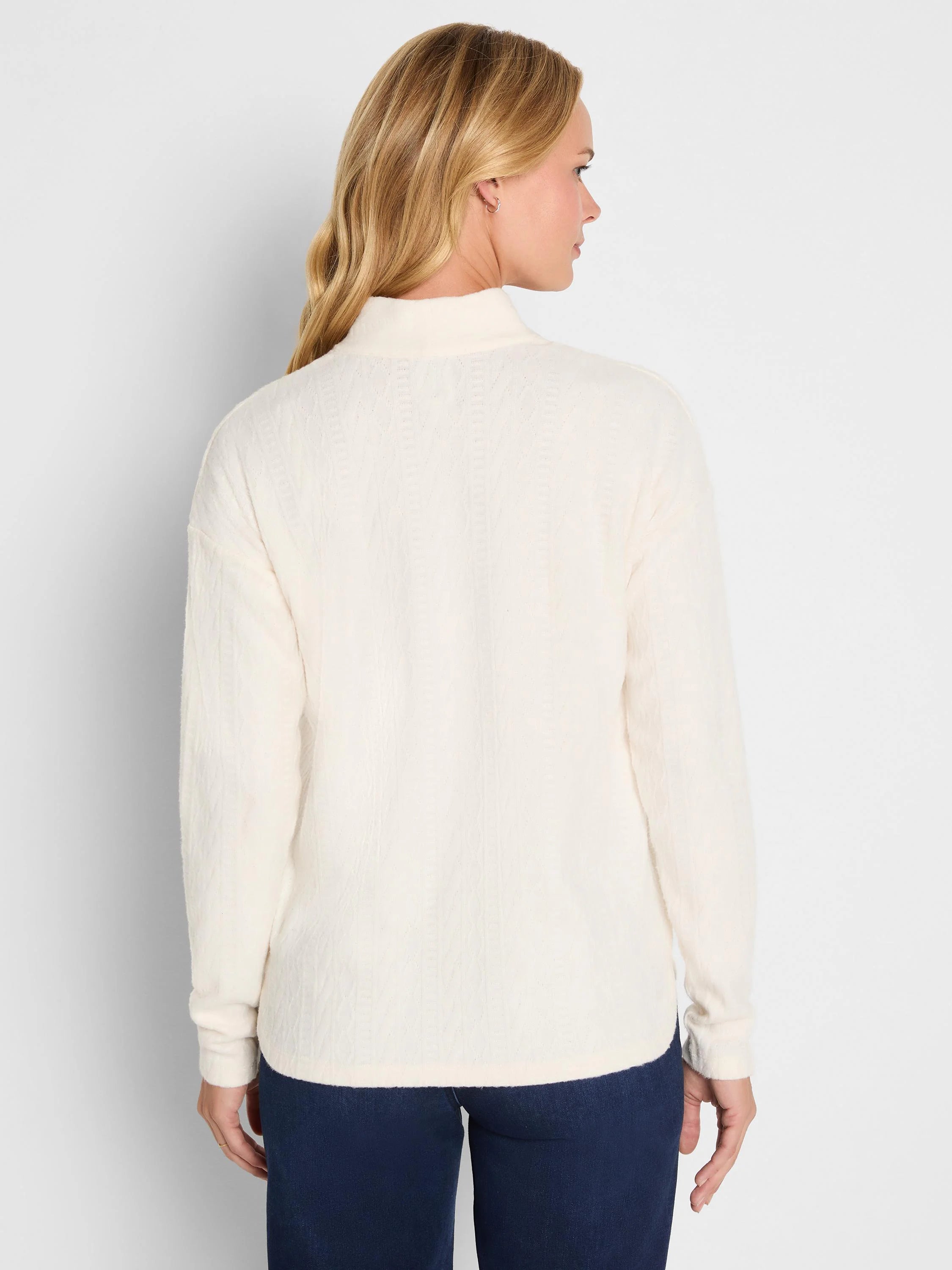 Off-white high-neck top with a subtle cable knit pattern, shown from behind.