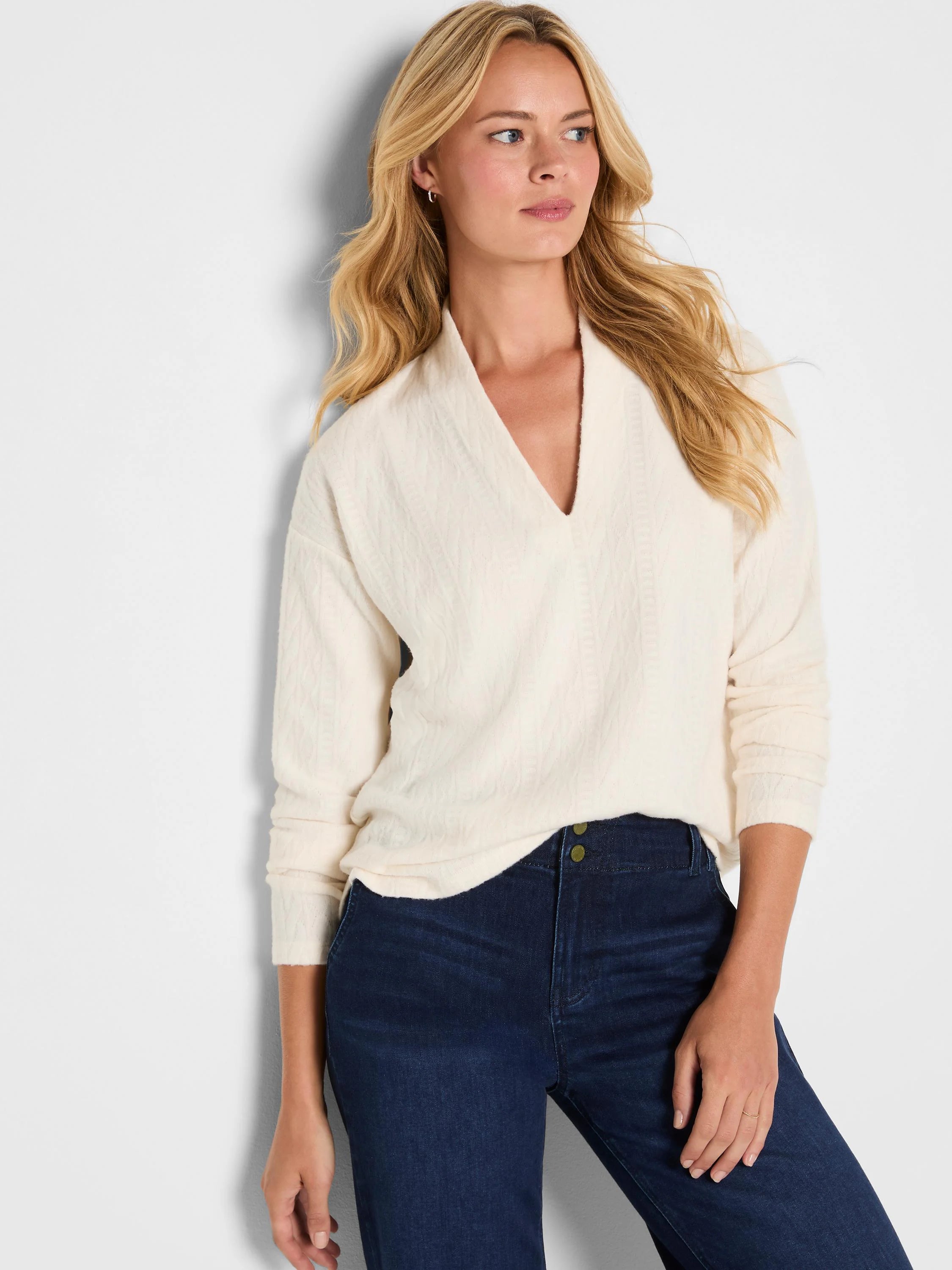Off-white cable knit top with a structured V-neck and relaxed fit.