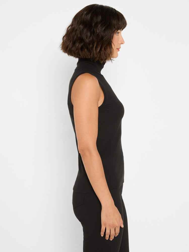 Black ribbed knit turtleneck tank, sleeveless and form-fitting. Modeled in profile view.