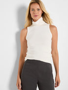 Off-white ribbed knit sleeveless turtleneck tank, form-fitting.