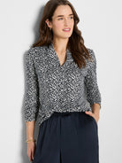 Black and off-white knit top with an abstract geometric pattern, V-neck, and 3/4 length ruched sleeves.